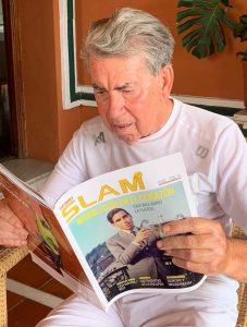 Manolo Santana lee el número donde protagoniza la portada de Grand Slam: Miguel Ángel Zubiarrain.
