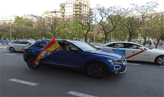 Aficionados en coche mostrando la bandera de España con el escudo del Real Madrid: Ravelo.
